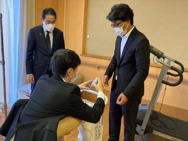 担当者が視察者へ介護支援ロボットの説明を行っている